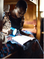 mujer leyendo libro con linterna